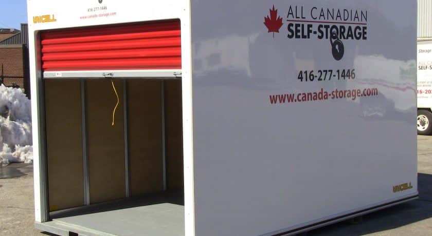 white storage unit with red door in parking lot, yellow string on door handle