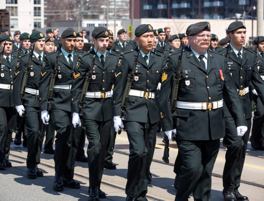 Group of men walking the city streets, wearing a black military uniform