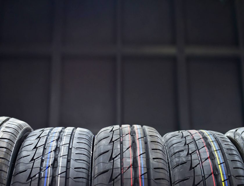 black background, five tires in the front with thin blue, yellow, white, and red stripes