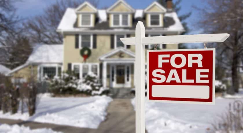 Home For Sale Sign in Front of Snowy New House