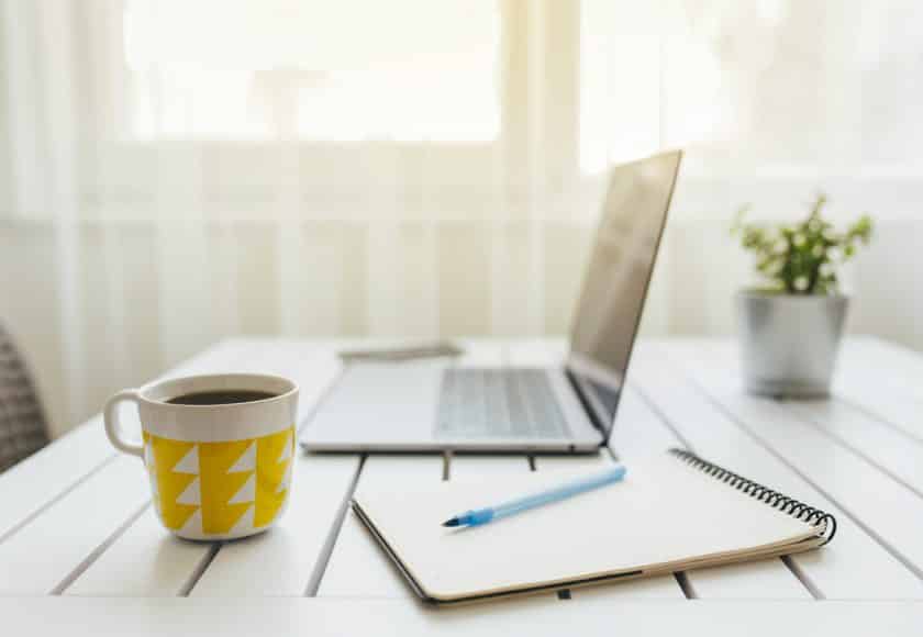 Cropped shot of technology and a notebook on a desk in an empty home office during the day