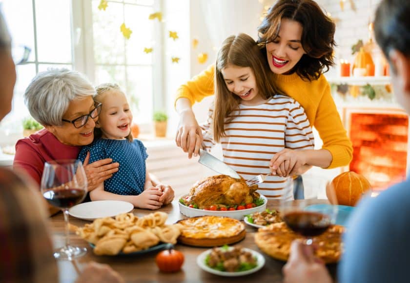 Family sitting at the table and celebrating holiday. Grandparents, mother, father and children. Traditional dinner.